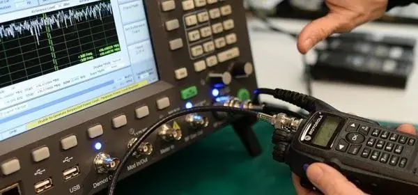 Radio conectado al analizador para ajustar frecuencia y potencia