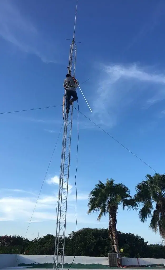 Técnico en lo alto de la torre arriostrada